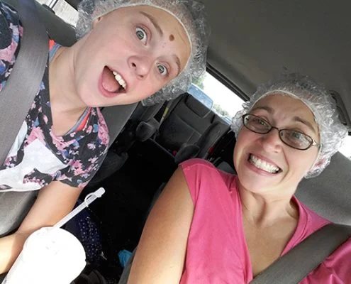Two happy girls in the car with shower caps from lice treatment
