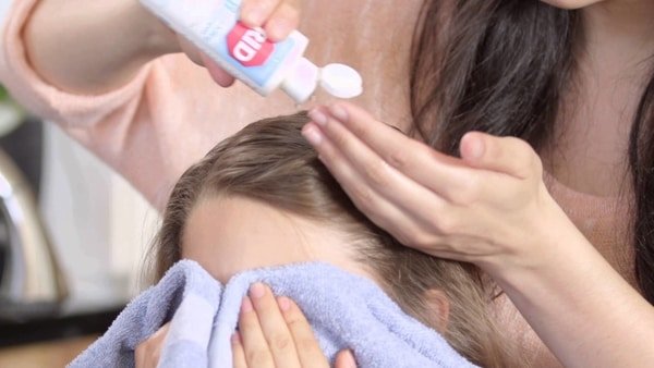 Parent using rid lice shampoo on child in Spring Grove Illinois